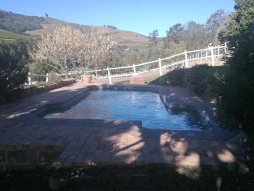 a large pool of water with a white fence at Belcharto Accommodation in Stellenbosch