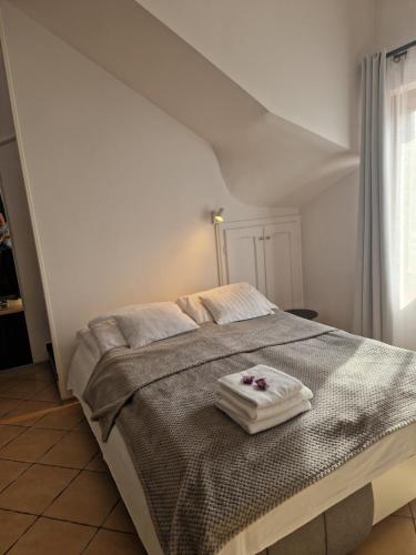 a bedroom with a bed with two towels on it at Martina apartman in Gyula