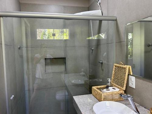 uma casa de banho com uma cabina de duche em vidro e um lavatório. em Casa da 17 - Lago Sul em Brasília