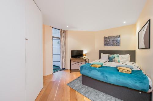 a bedroom with a large bed and a television at Pollen Street, Three-bedroom Flat in London