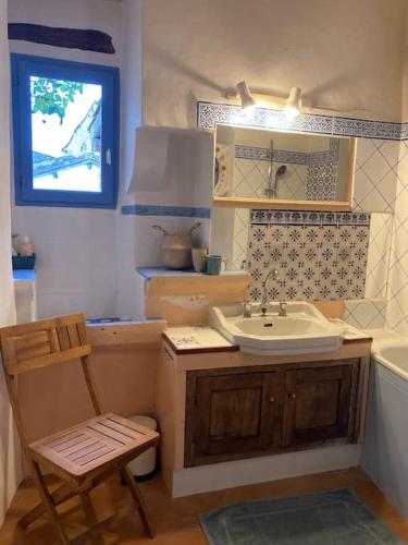 La salle de bains est pourvue d'un lavabo et d'une chaise. dans l'établissement La nuit de la chouette, à Bruniquel