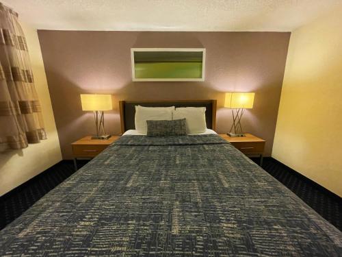 1 cama grande en una habitación de hotel con 2 lámparas en Lakeside Inn, en Wakefield