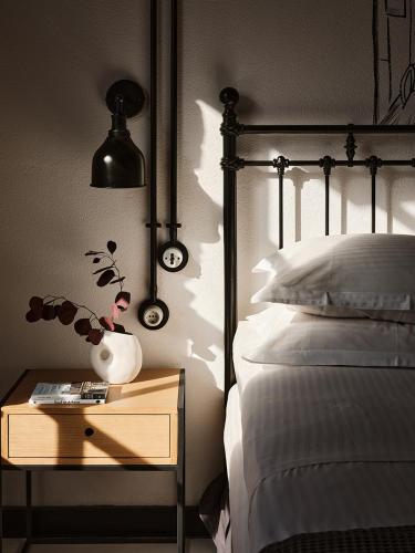 a bedroom with a bed and a nightstand with a table with a lamp at Not Boutique Hotel in Athens