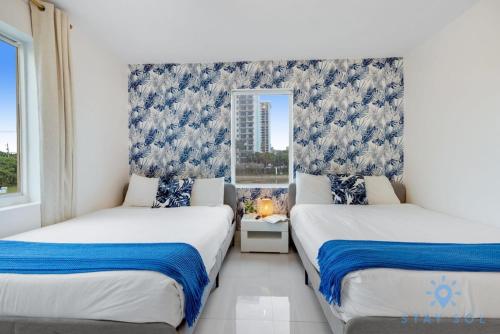 two beds in a room with a window at Free Parking - Bay View - Pool - Step To Beach in Hollywood