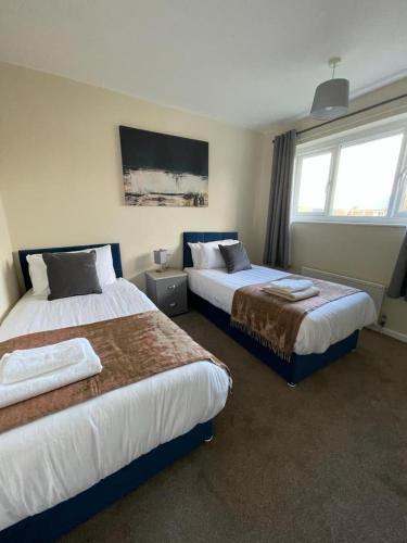 a hotel room with two beds and a window at Stunning 3 bedrooms house with Garden and Free Parking in Barnsley