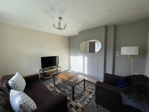 a living room with a couch and a table at Stunning 3 bedrooms house with Garden and Free Parking in Barnsley