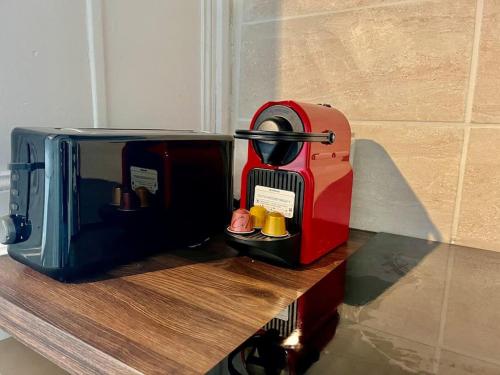 un grille-pain rouge assis au-dessus d'un comptoir dans l'établissement «Studio 1 » Rue Huchette -DABNB, à Limoges