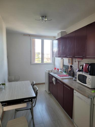 une cuisine avec des placards violets et une table. dans l'établissement Elégant apparemment 60m2 climatisé, à Avignon