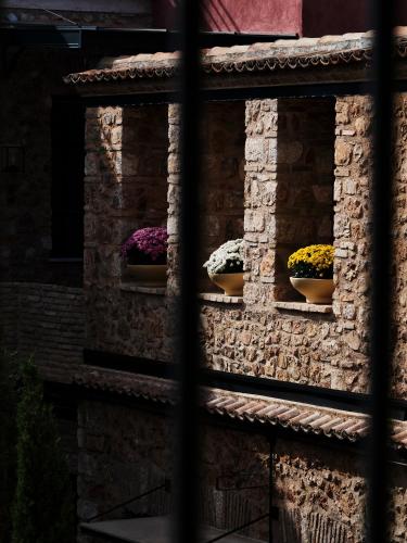 two pots of flowers on a stone wall at Not Boutique Hotel in Athens