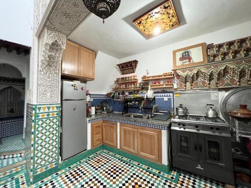a kitchen with wooden cabinets and a tile floor at Dar Sunrise Fes in Fès
