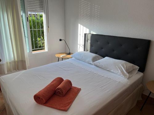 a bedroom with a bed with two towels on it at Habitación con baño Malva in Lepe