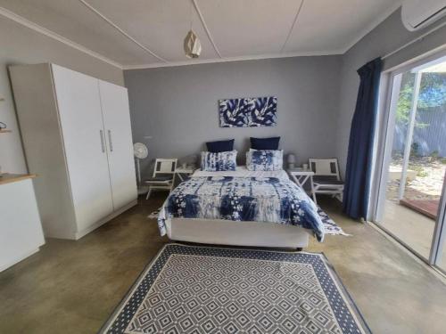 a bedroom with a bed and a large window at Karoo Nest - Calitzdorp in Calitzdorp