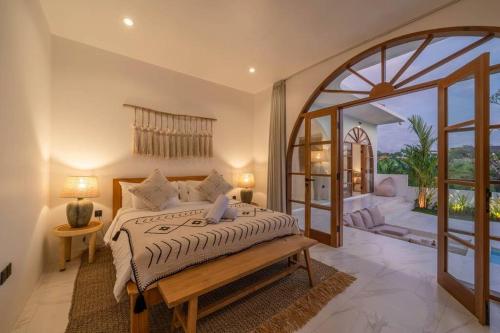 een slaapkamer met een bed en een groot raam bij Villa AMARYA - NEW Tropical & Modern 3BR Central - Canggu beach in Canggu