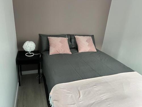 - une chambre avec un lit doté d'oreillers roses et d'une table dans l'établissement Montmartre Sacré Cœur Appartement Refait à Neuf Paris 18ème - 4 P, à Paris