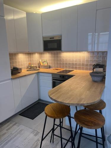 une cuisine avec une table en bois et deux tabourets dans l'établissement Montmartre Sacré Cœur Appartement Refait à Neuf Paris 18ème - 4 P, à Paris
