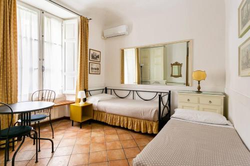1 dormitorio con cama, mesa y espejo en Scipioni Suites, en Roma