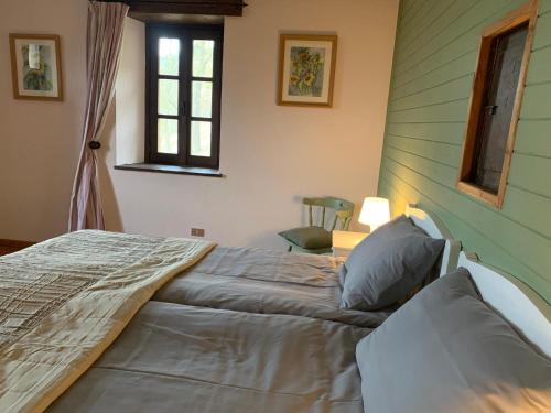 a bedroom with a bed in a room with a window at Agriturismo La Collina degli Scoiattoli in Cravanzana