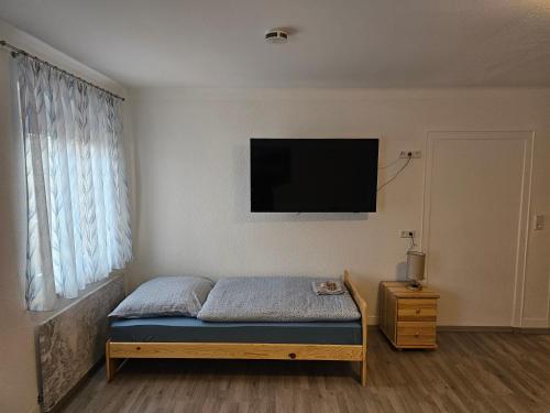 a bedroom with a bed and a flat screen tv at Pension Ochsen 