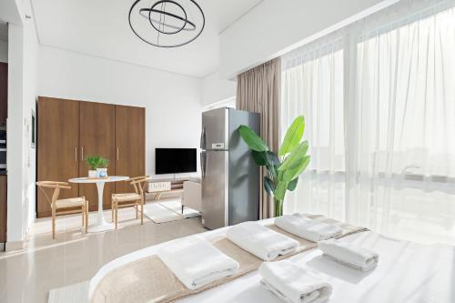 a white room with a bed and a dining room at Silkhaus Vacation Homes Luxury Studio in Residential Neighborhood in Dubai
