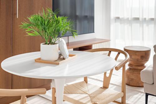 a white table with a plant on it in a living room at Silkhaus Vacation Homes Luxury Studio in Residential Neighborhood in Dubai