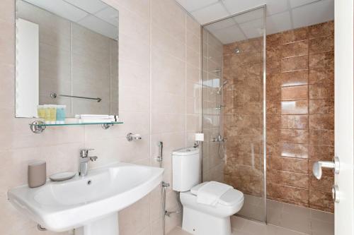 ein Bad mit einem WC, einem Waschbecken und einer Dusche in der Unterkunft Silkhaus Luxury Studio in a Residential Neighborhood in Dubai