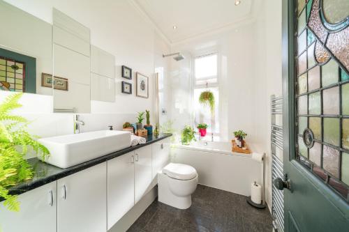 a bathroom with a sink and a toilet and a tub at Desswood Aberdeen City Centre Apartment in Aberdeen