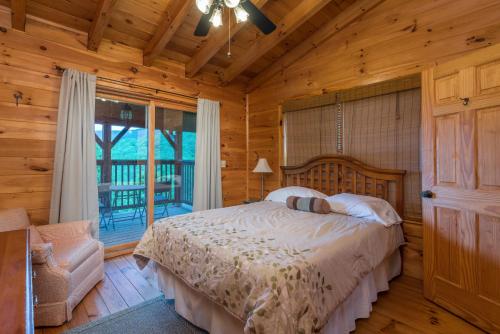 una camera con un letto in una baita di tronchi di Firefly Lodge Private Log Cabin with Mountain Views! a Black Mountain