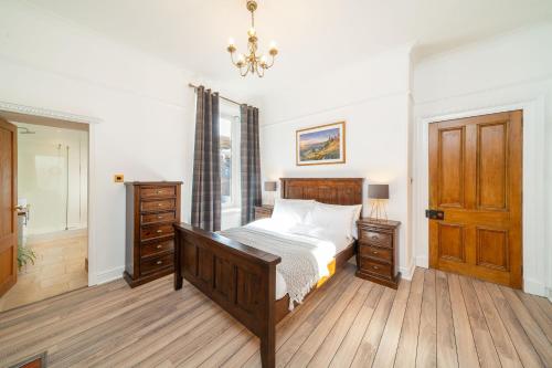 a bedroom with a bed and a dresser and a window at Desswood Aberdeen City Centre Apartment in Aberdeen