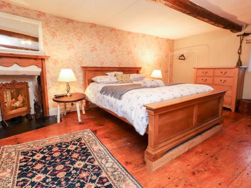 ein Schlafzimmer mit einem großen Bett und einem Kamin in der Unterkunft Quirky in Chipping in Preston