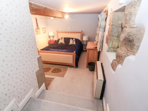 ein kleines Schlafzimmer mit einem Bett und einer Treppe in der Unterkunft Quirky in Chipping in Preston