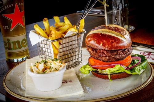 a plate with a hamburger and french fries on a table at Grosvenor Pulford Hotel & Spa in Pulford