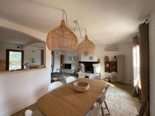 uma sala de jantar com uma mesa de madeira e cadeiras em Villa 4-6 pers Luberon Côté Oliviers em Gargas