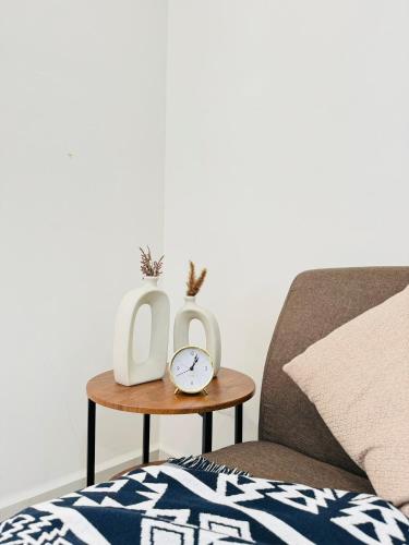 a table with two clocks on it next to a couch at CoreSoho Suite by BKAstaycation KotaWarisan Sepang KLIA Airport, Free Wifi in Sepang