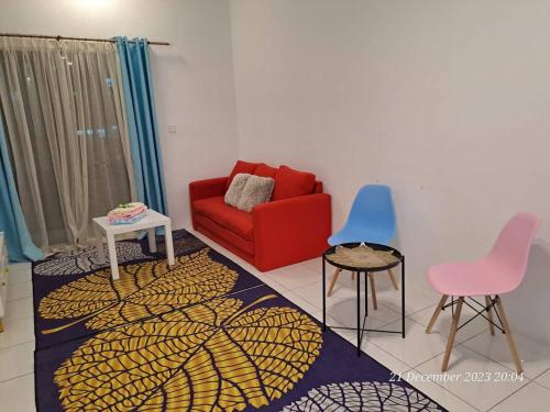 a living room with a red couch and two chairs at İmpiana Homestay near PUTRAJAYA, CYBERJAYA, Musliem Only,WIFI,Netflix in Kampung Dengkil