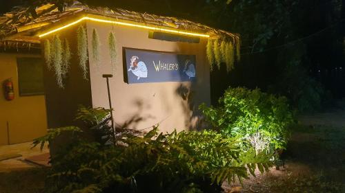 a sign on the side of a building with plants at Melina Beach Front Bungalows in Tha Lane Bay