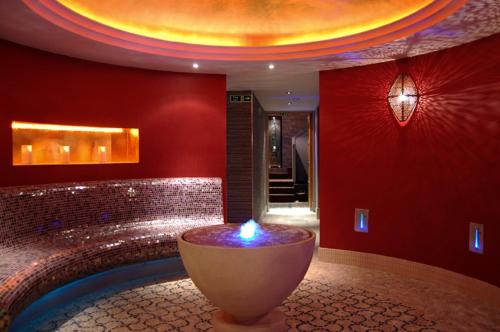 a room with a large tub with a candle in it at Grosvenor Pulford Hotel & Spa in Pulford