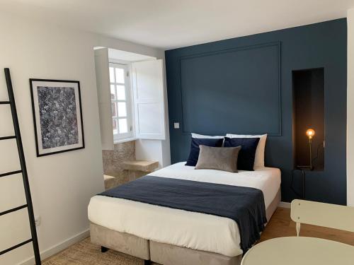 Schlafzimmer mit einem großen Bett mit blauem Kopfteil in der Unterkunft Casa do Museu in Coimbra