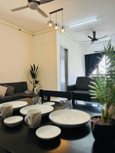 a living room with a table with plates on it at CoreSoho Suite by BKAstaycation KotaWarisan Sepang KLIA Airport, Free Wifi in Sepang