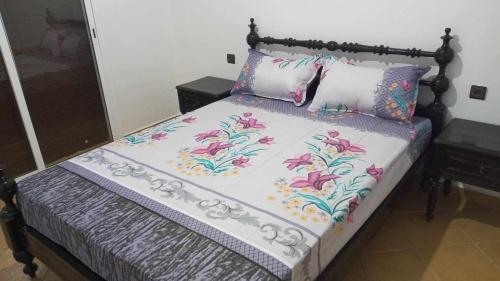ein Bett mit rosa Blumen und zwei Kissen in der Unterkunft Villa The View in Tétouan