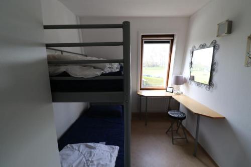 a room with two bunk beds and a desk at Zouterik 5* in Nieuwvliet