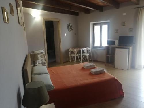 a bedroom with a bed and a kitchen with a table at Domo Serra E Mesu in Magomadas