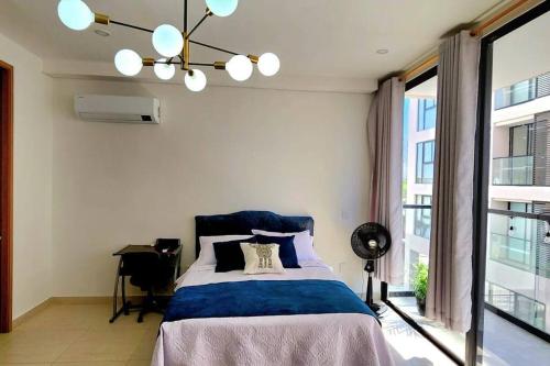 Un dormitorio con una cama y una ventana grande. en Loft completo con balcón a 5 min de la playa, en Santa Marta