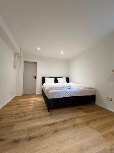 una camera con letto e pavimento in legno di Studio Glishorn Blick a Brig