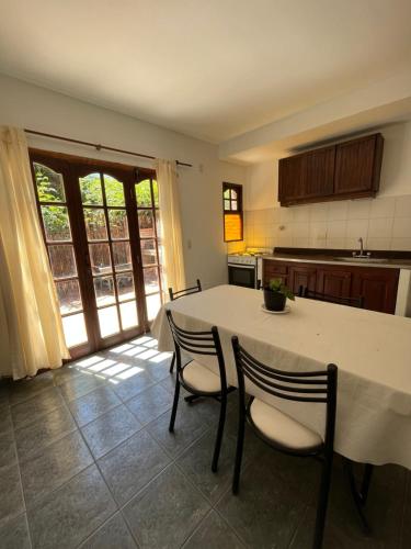 uma cozinha com uma mesa branca e cadeiras num quarto em Duplex 2 - Rama Caida em Pinamar