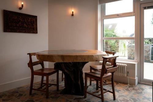 a table in a room with two chairs and a window at Amber Lights Coastal Getaway, Greatstone in Greatstone