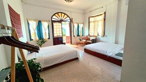 a bedroom with two beds and a living room at Maidi Homestay Mui Ne in Mui Ne