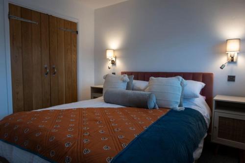 a bedroom with a large bed with blue pillows at Amber Lights Coastal Getaway, Greatstone in Greatstone