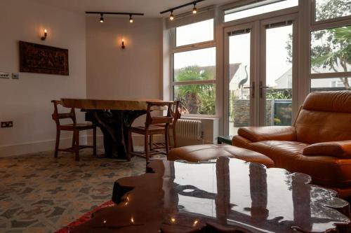 uma sala de estar com um sofá e uma mesa em Amber Lights Coastal Getaway, Greatstone em Greatstone