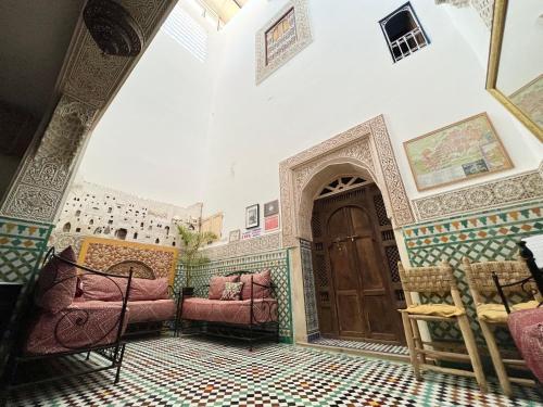 a room with two chairs and a wooden door at Dar Sunrise Fes in Fès
