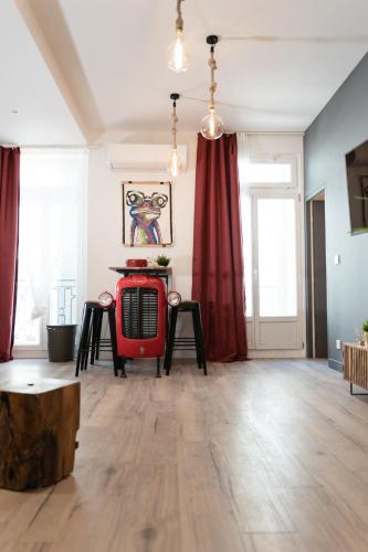 un salon avec des rideaux rouges et un radiateur rouge dans l'établissement Le comptoir des grenouilles, à Marseille